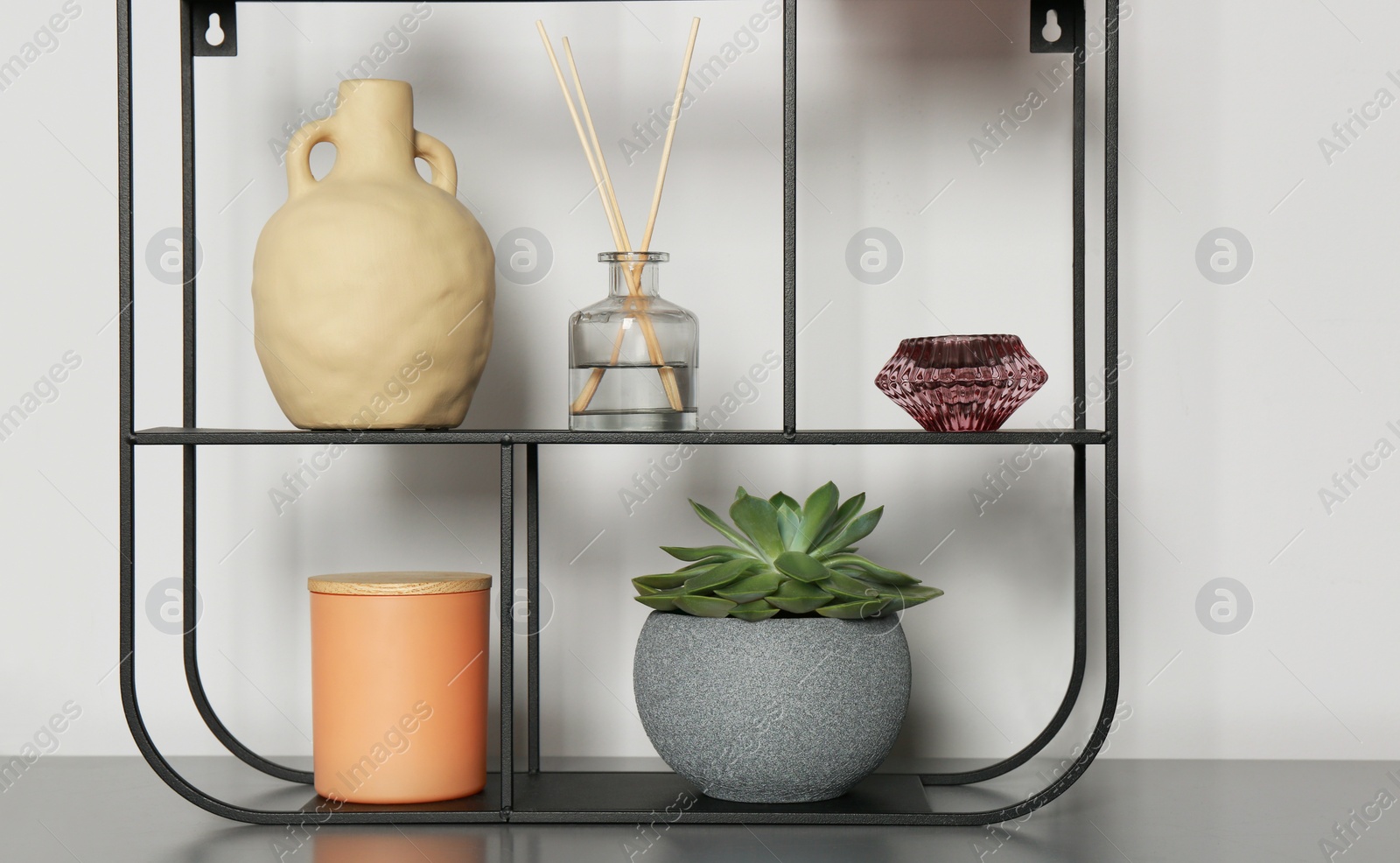 Photo of Shelving unit with decorative elements on chest of drawers. Interior design