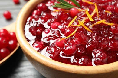 Photo of Fresh cranberry sauce with orange peel and rosemary in bowl, closeup