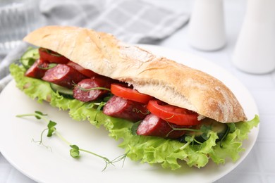 Photo of Delicious sandwich with sausages and vegetables on white table, closeup