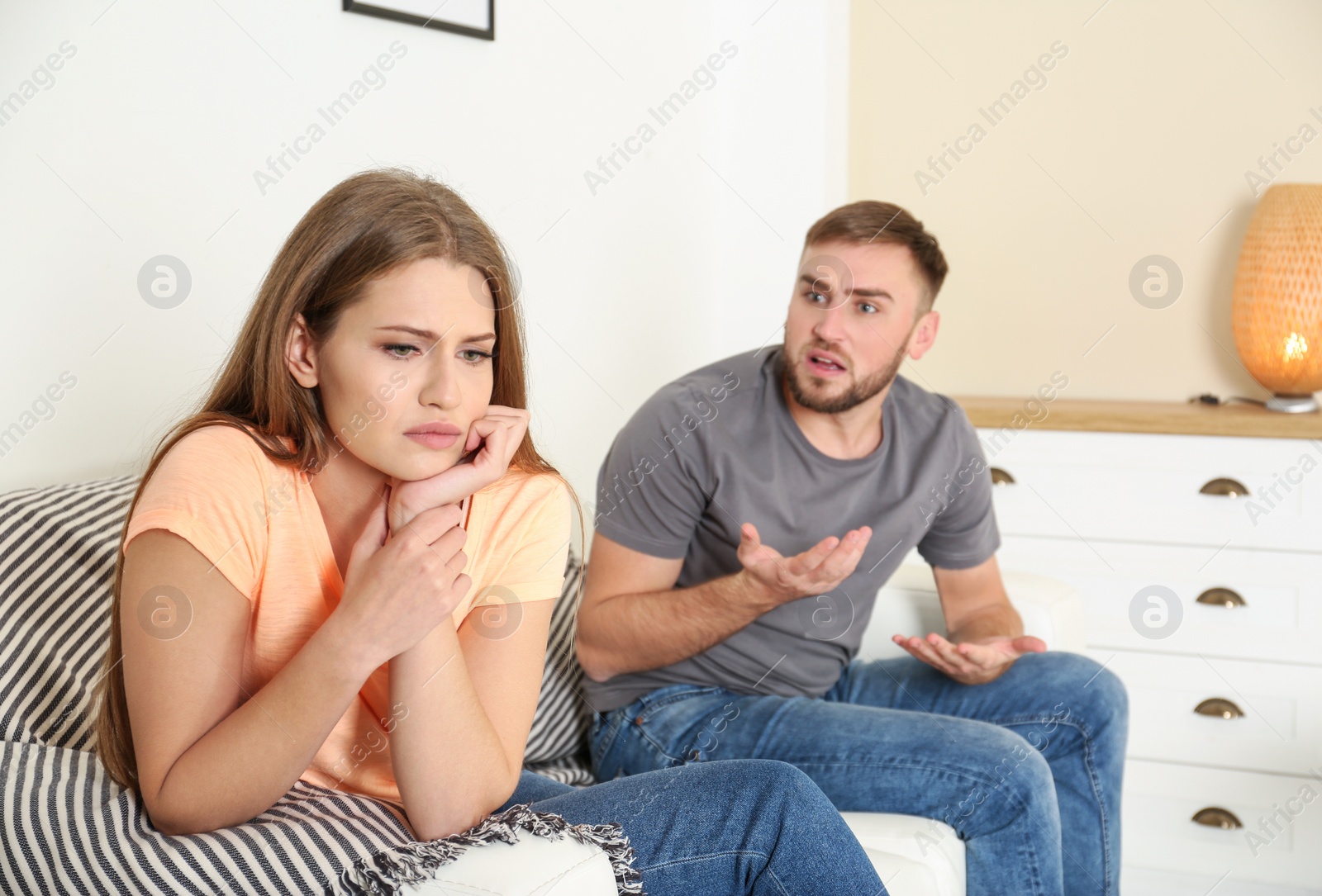 Photo of Young couple having argument in living room. Relationship problems