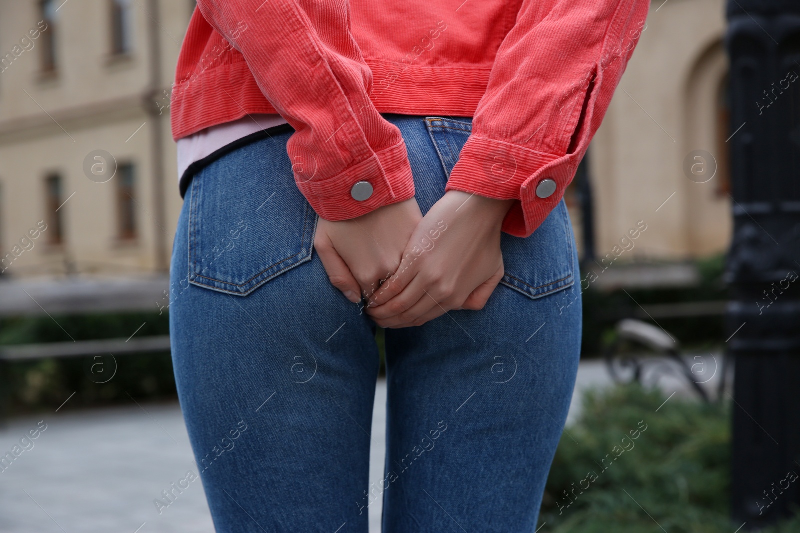 Photo of Woman suffering from hemorrhoid pain outdoors, closeup