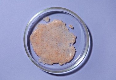 Photo of Petri dish with sample on lilac background, top view