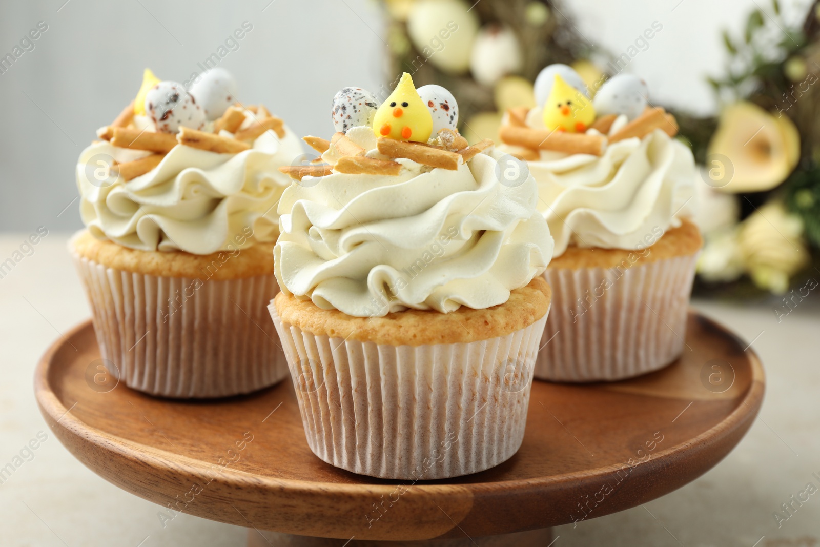 Photo of Tasty Easter cupcakes with vanilla cream on gray table, closeup