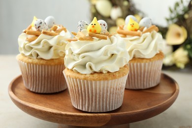 Tasty Easter cupcakes with vanilla cream on gray table, closeup