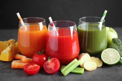 Different tasty juices and fresh ingredients on grey table