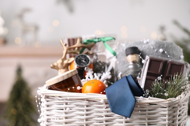 Photo of Wicker basket with Christmas gift set on blurred background