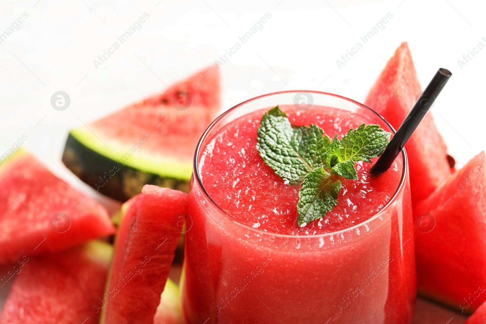 Photo of Summer watermelon drink in glass and sliced fresh fruit on table, closeup