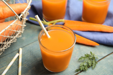 Photo of Freshly made carrot juice on wooden table