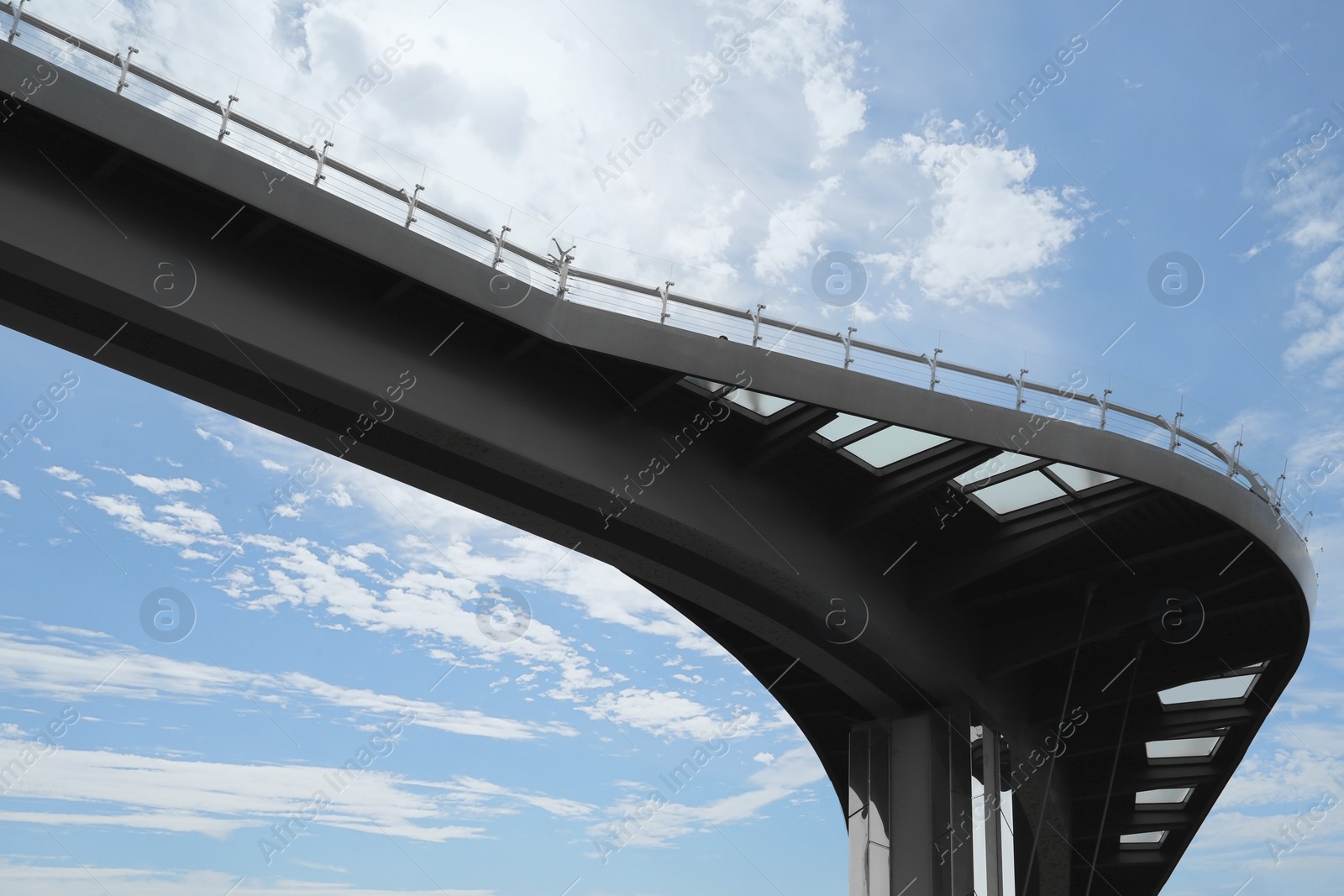 Photo of Beautiful pedestrian bridge with viewing platform against cloudy sky, low angle view