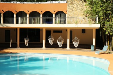 Photo of Hotel building with hammock and clean pool outdoors