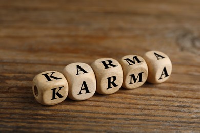 Word Karma made of cubes with letters on wooden table