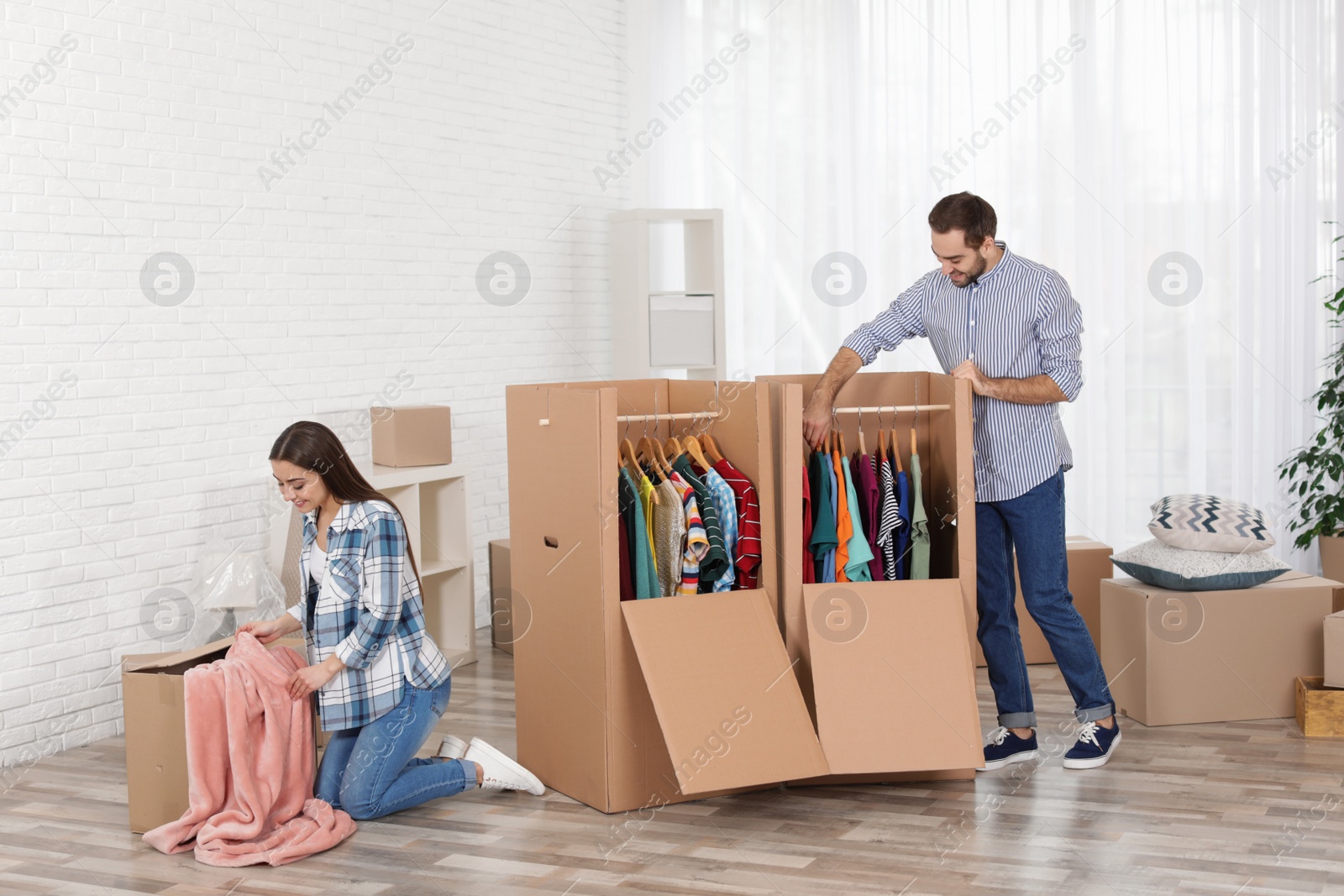 Photo of Young couple near wardrobe boxes at home