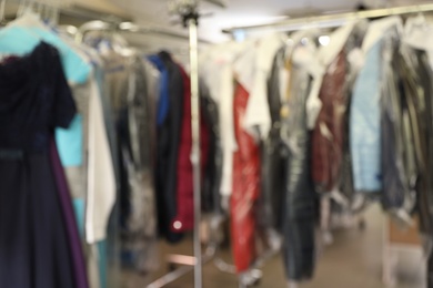 Blurred view of racks with clothes in dry-cleaning