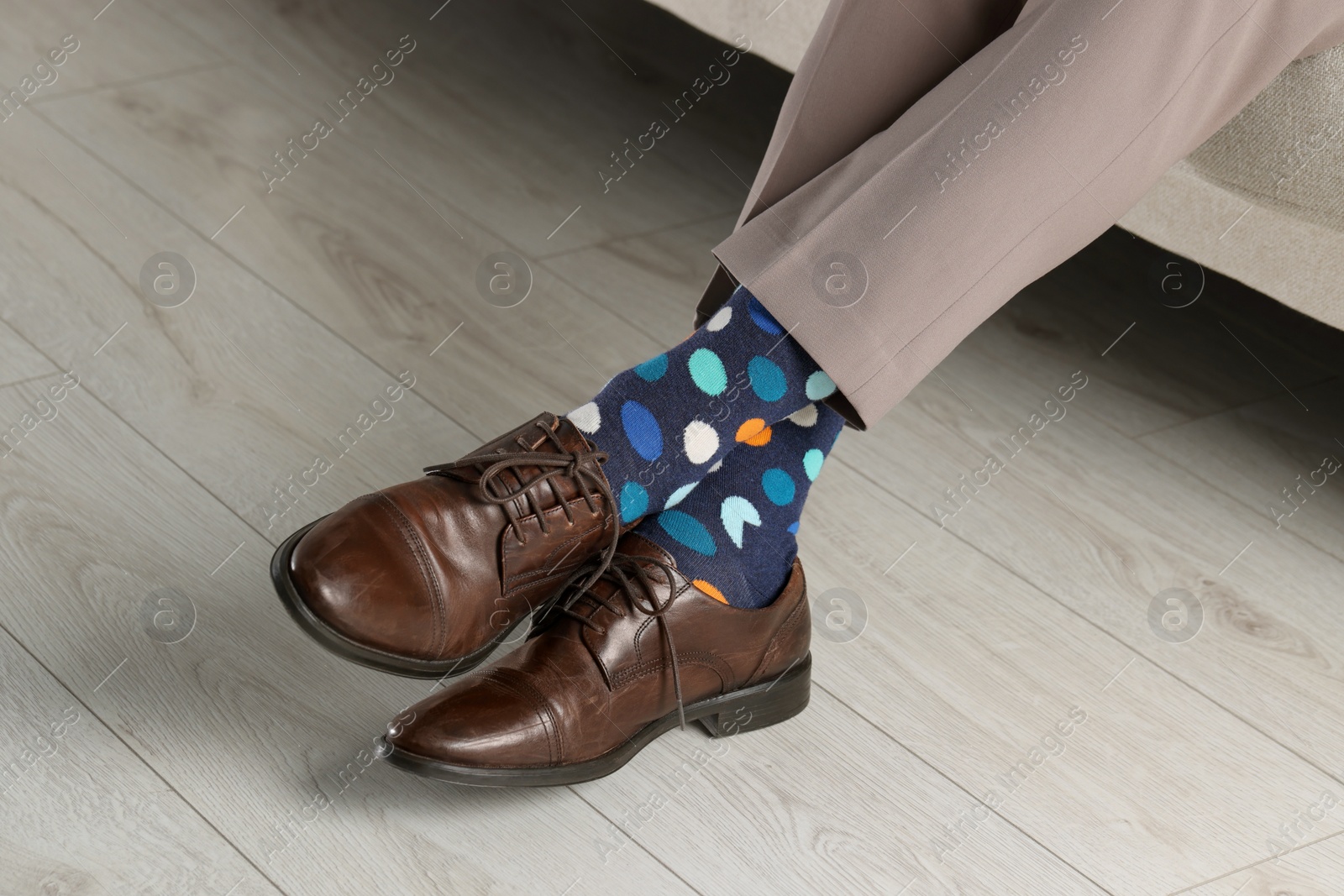 Photo of Man wearing stylish shoes and colorful socks indoors, closeup