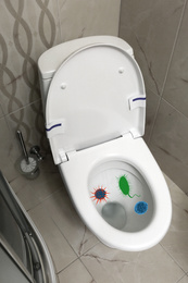Image of Illustration of microbes on toilet bowl in bathroom, above view 