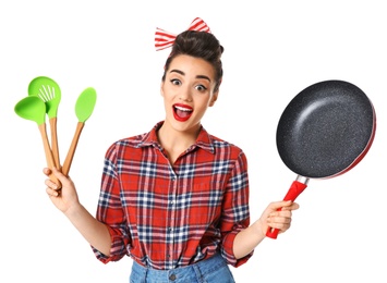 Photo of Funny young housewife with frying pan and cooking utensils on white background