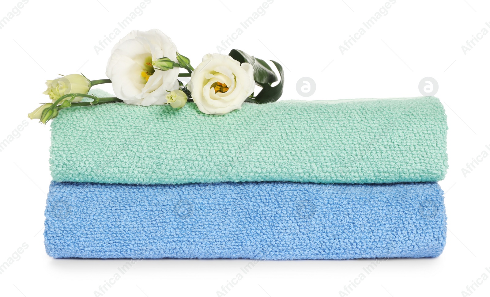 Photo of Folded clean soft towels with flowers isolated on white