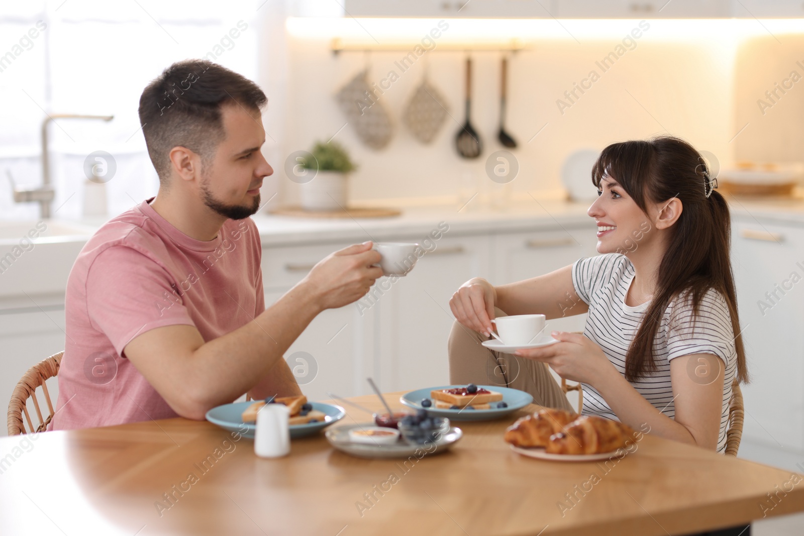 Photo of Happy couple having tasty breakfast at home