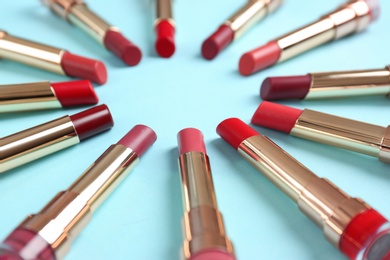 Photo of Composition with different stylish lipsticks on color background