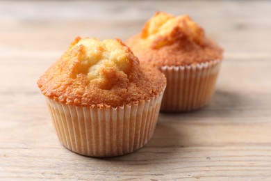 Delicious sweet muffins on wooden table, closeup. Space for text