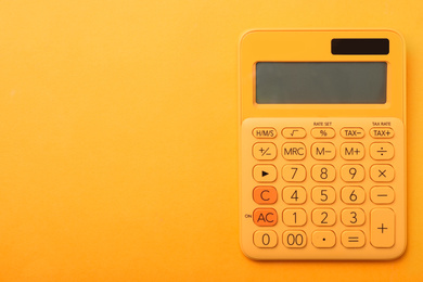 Photo of Calculator on orange background, top view with space for text. Tax accounting concept