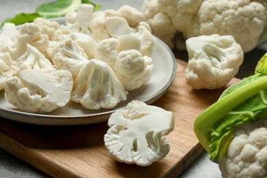 Photo of Cut fresh raw cauliflowers on grey table, closeup