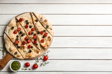 Photo of Flat lay composition with focaccia bread on white wooden table. Space for text