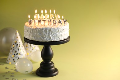Photo of Tasty birthday cake with burning candles on green background, closeup. Space for text