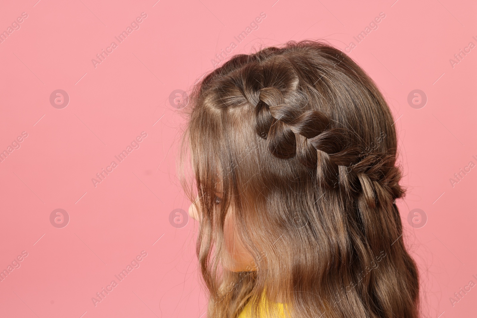 Photo of Cute little girl with braided hair on pink background. Space for text