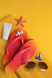 Photo of Flat lay composition with sunscreen and beach accessories on orange background