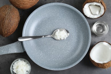 Photo of Flat lay composition with frying pan and organic coconut cooking oil on grey table