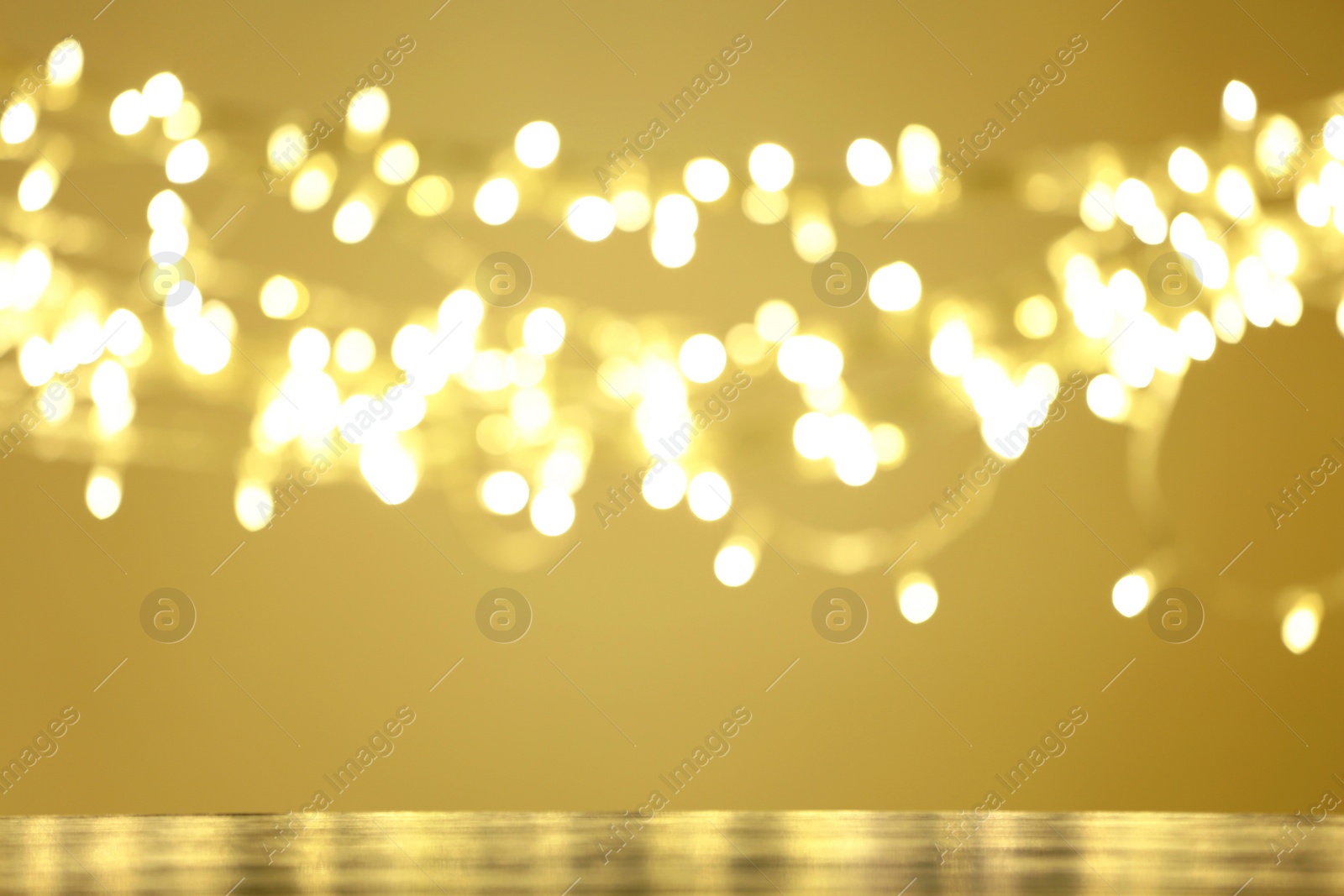 Photo of Empty table against golden bokeh background. Mockup for design