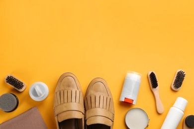 Flat lay composition with shoe care accessories and footwear on yellow background. Space for text