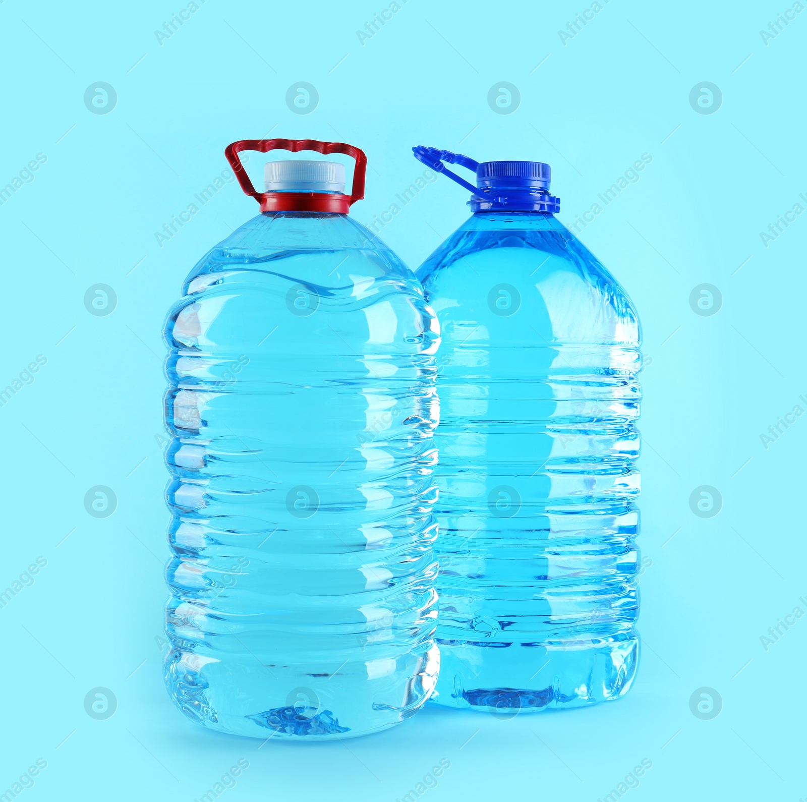 Photo of Large plastic bottles with pure water on color background