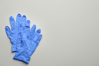 Pair of medical gloves on grey background, flat lay. Space for text