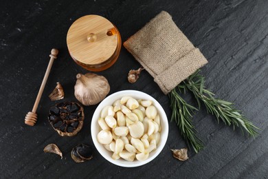 Photo of Flat lay composition with fresh and fermented black garlic on table
