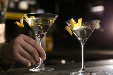 Photo of Barman serving glasses of lemon drop martini cocktail on counter, closeup
