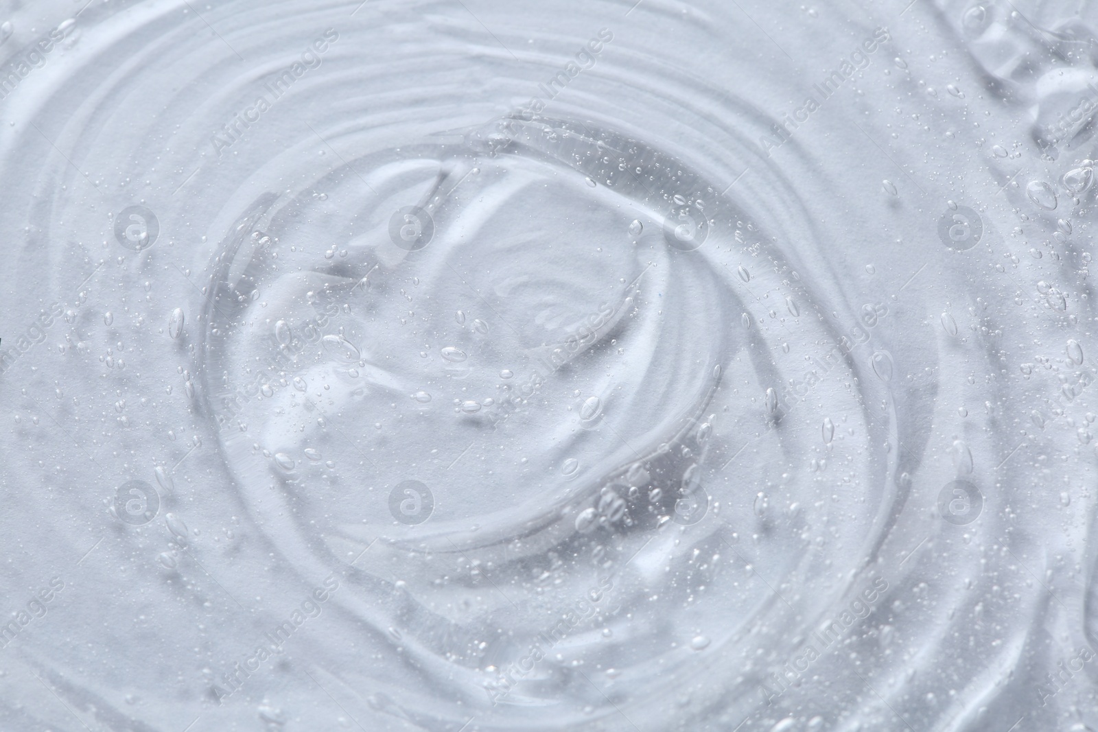 Photo of Clear cosmetic serum on white background, macro view