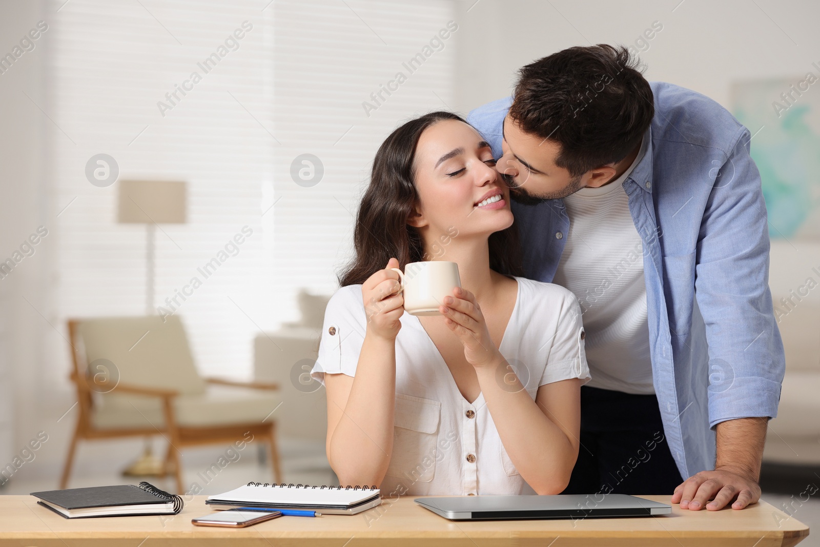 Photo of Cute couple. Man kissing his girlfriend at home, space for text