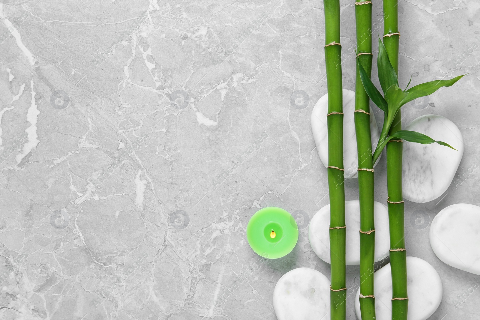 Photo of Flat lay composition with green bamboo stems on grey background. Space for text