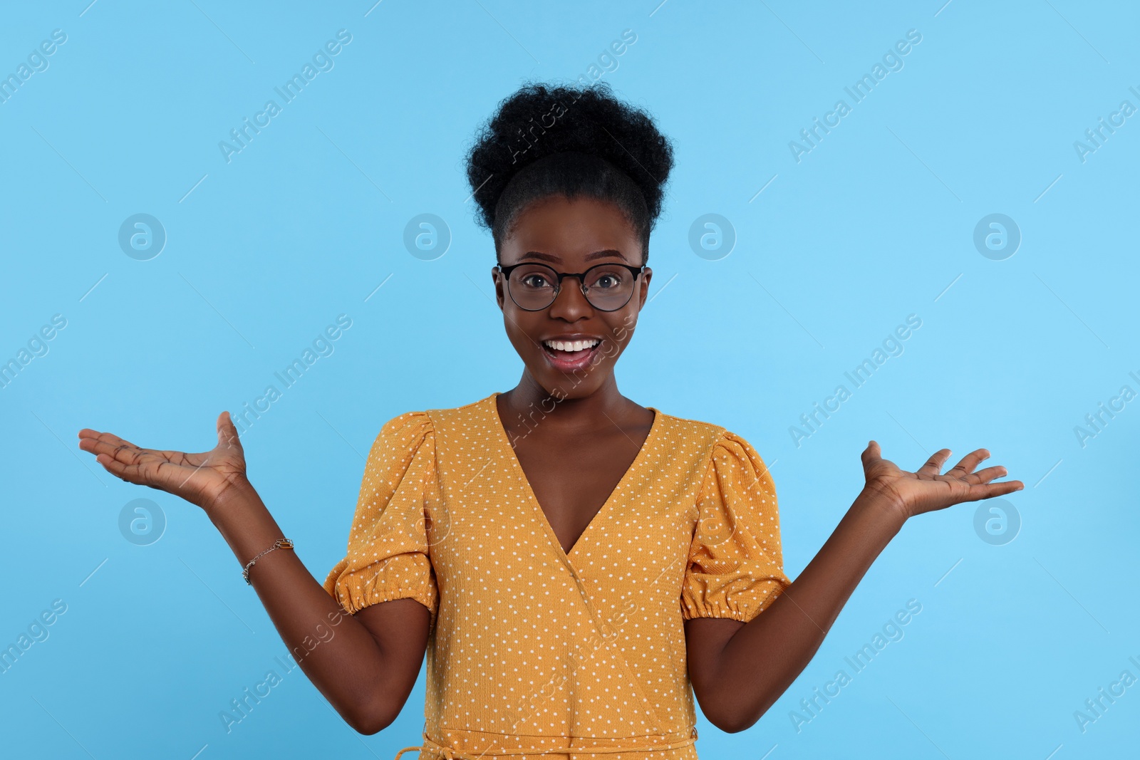 Photo of Portrait of beautiful young woman in eyeglasses on light blue background