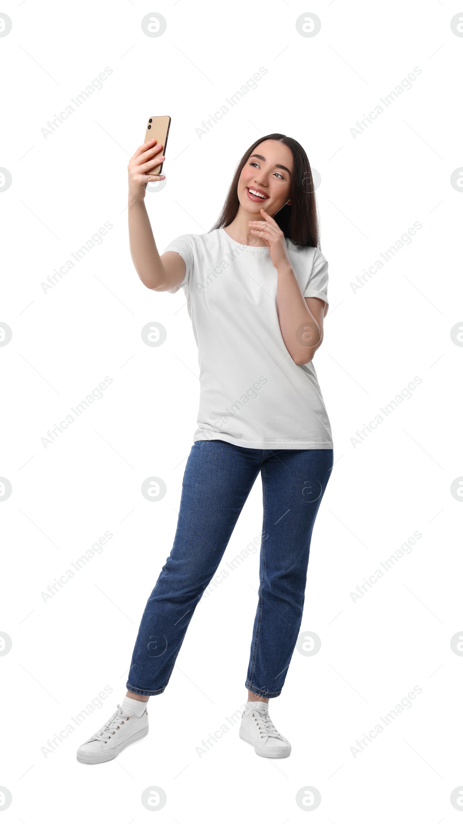 Photo of Smiling young woman taking selfie with smartphone on white background