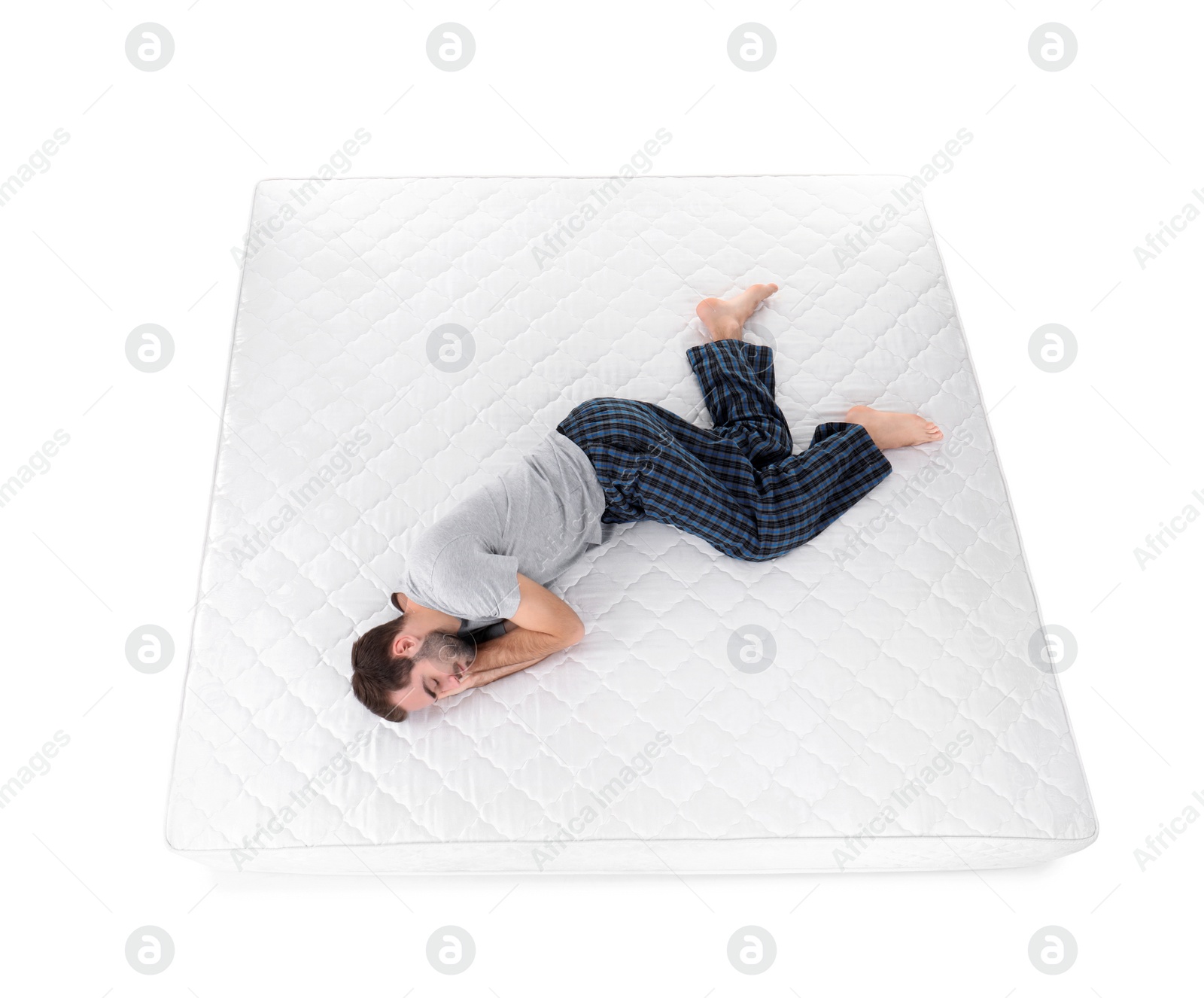 Photo of Young man sleeping on mattress against white background, above view