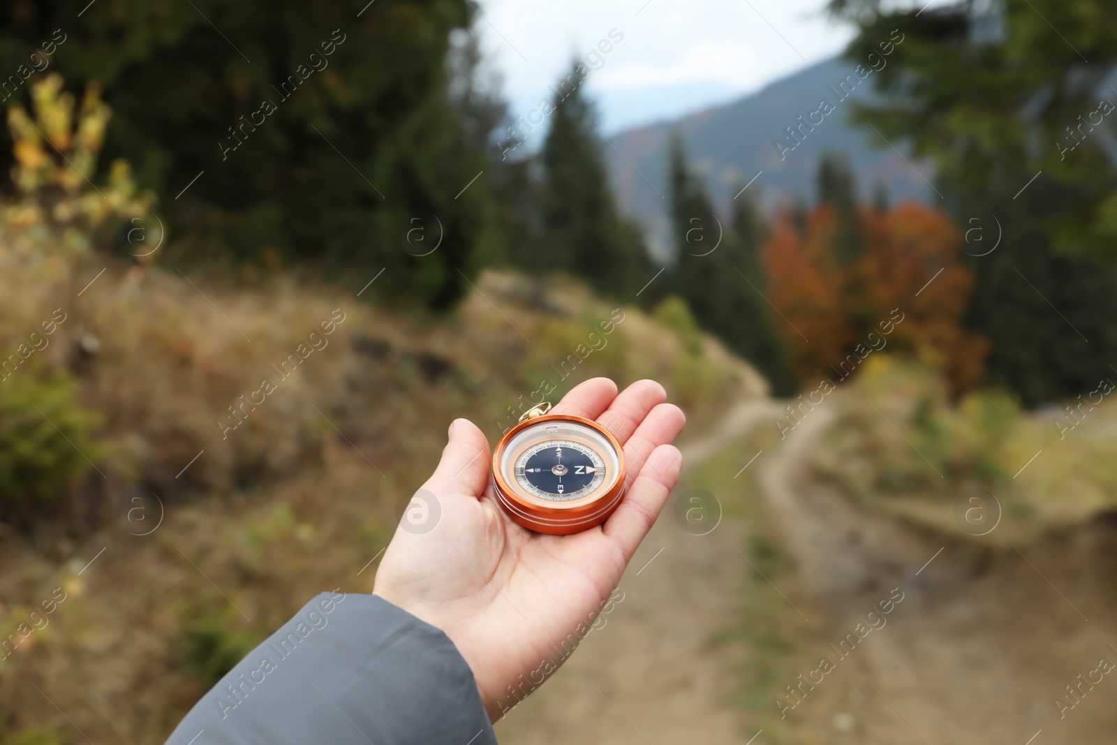 Photo of Woman using compass during journey in mountains, closeup