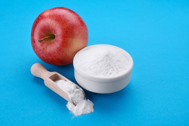 Photo of Sweet powdered fructose and fresh apple on light blue background