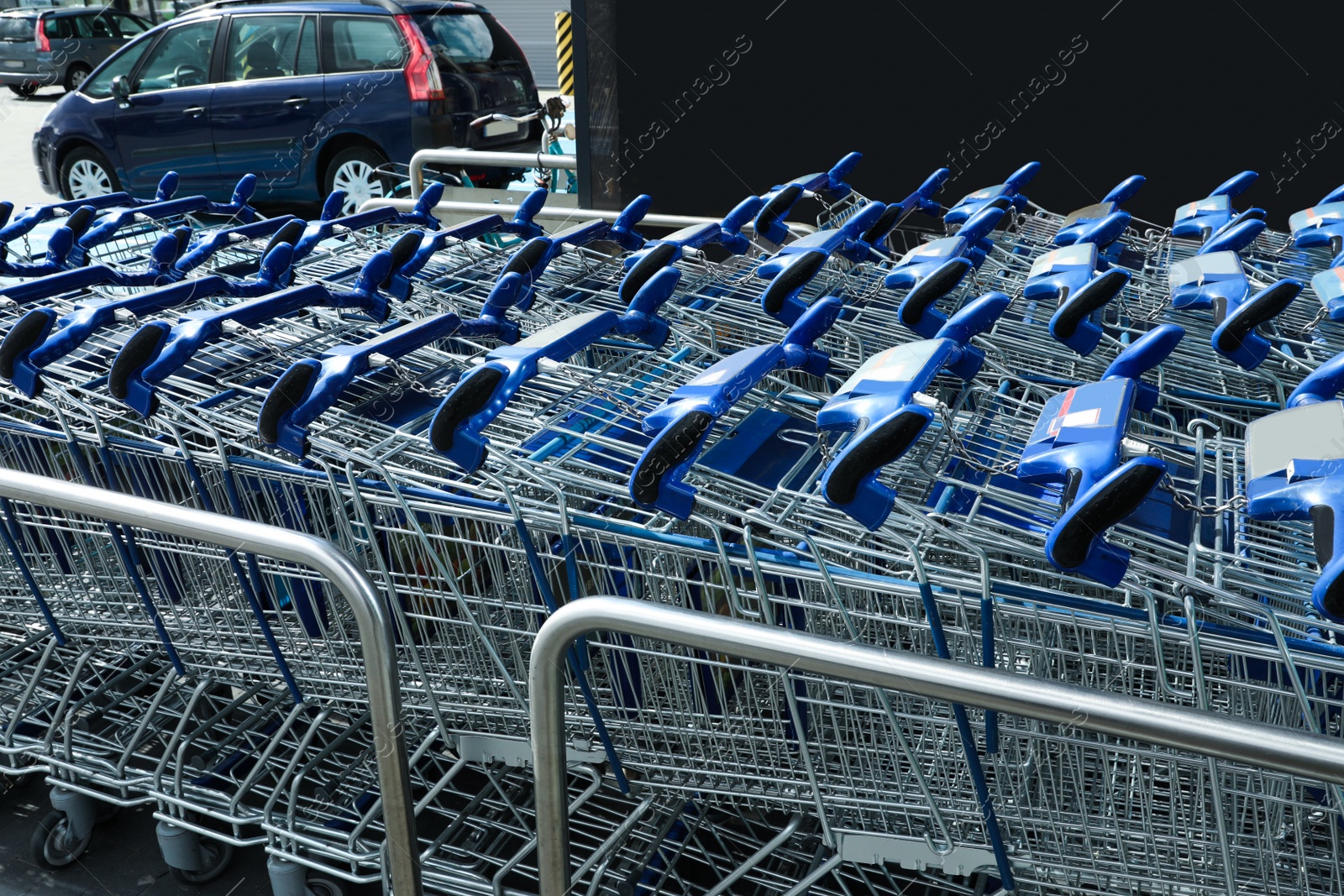 Photo of Many empty shopping carts near supermarket, closeup