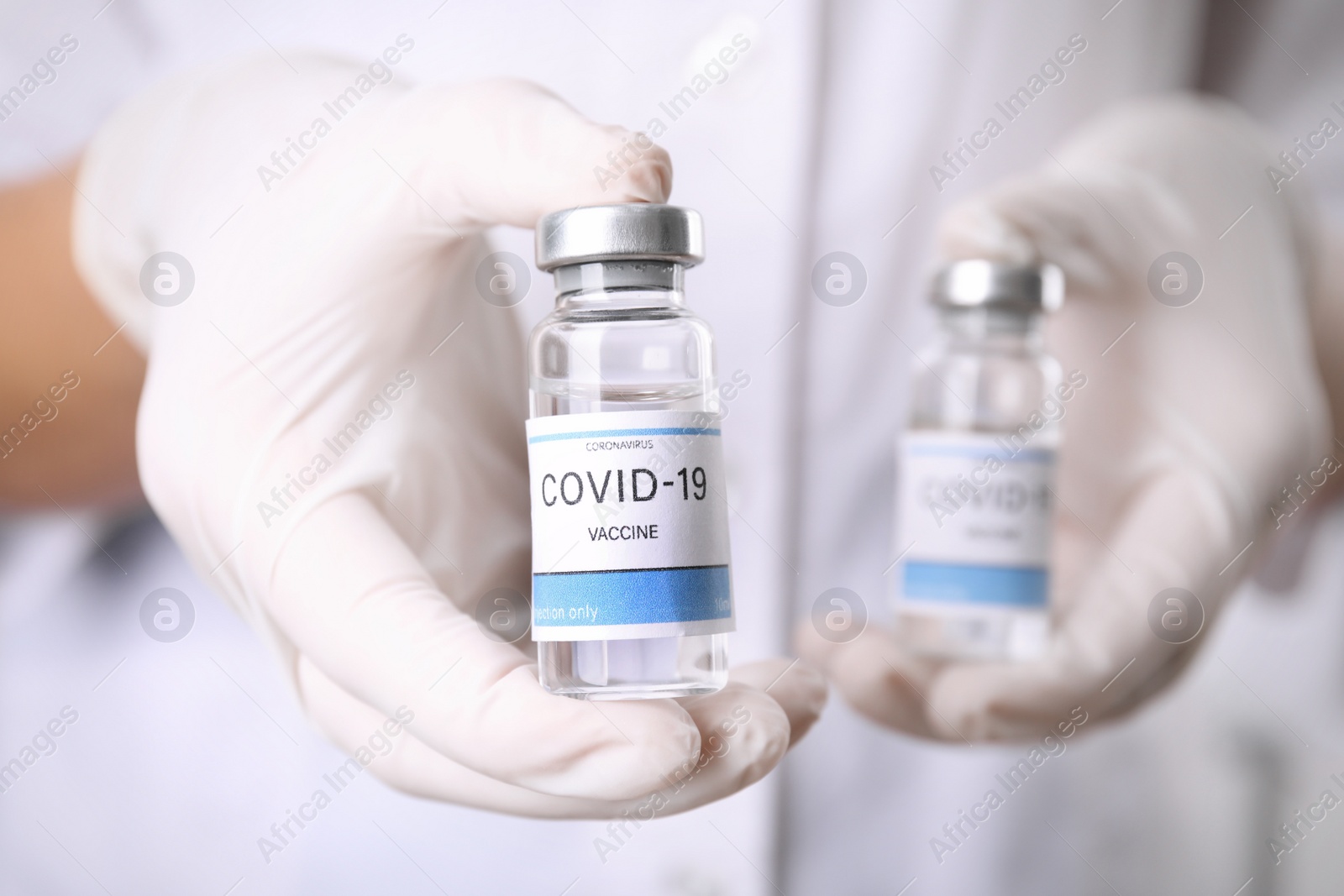 Photo of Doctor holding vials with vaccine against Covid-19, closeup