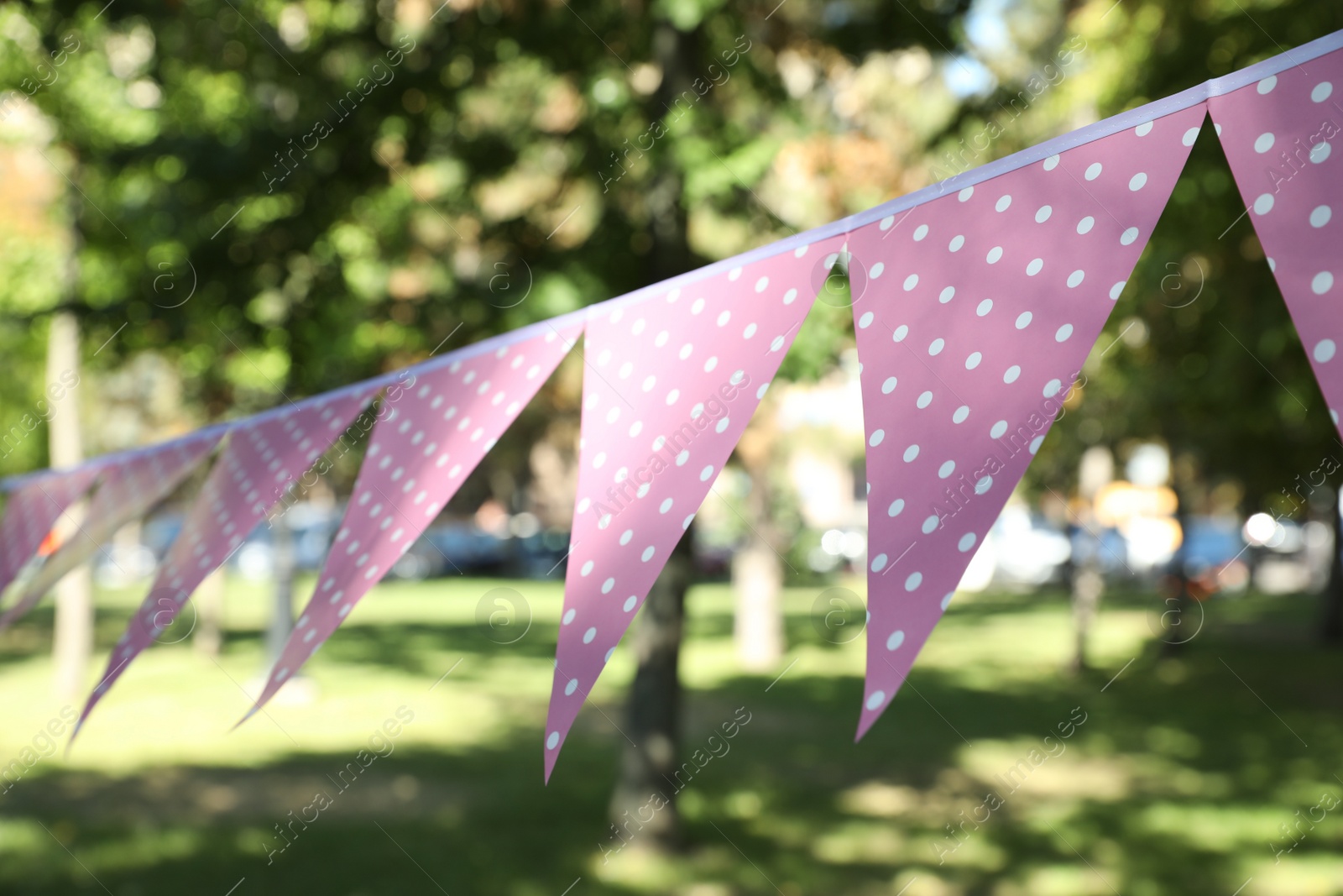 Photo of Pink bunting flags in park. Party decor