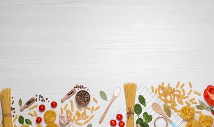 Photo of Flat lay composition with different types of pasta on white wooden table, space or text