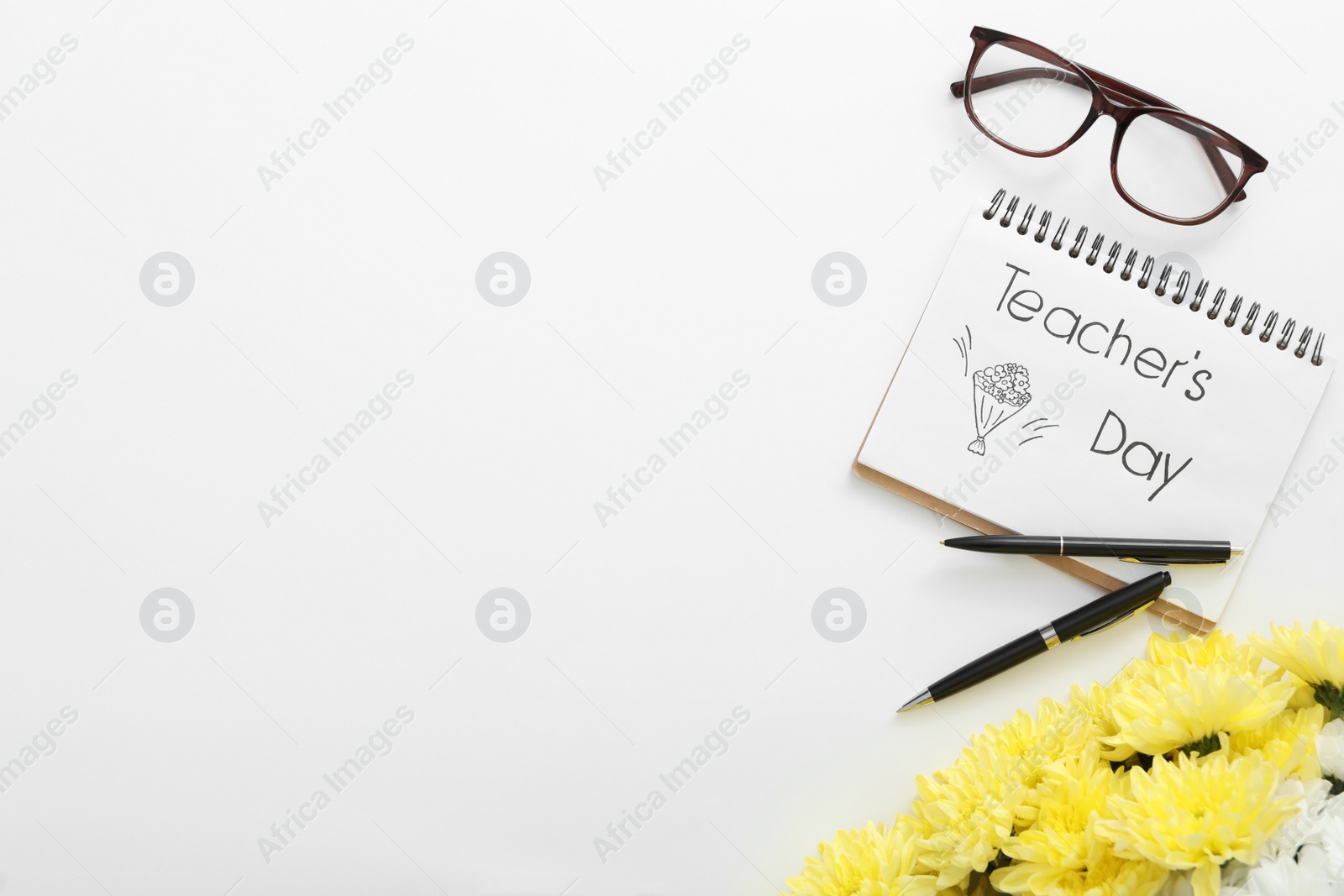 Photo of Beautiful flowers, glasses and notebook with words TEACHER'S DAY on white background, flat lay. Space for text